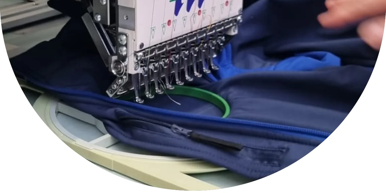 Borduurmachine brengt een logo aan op blauwe werkkledij