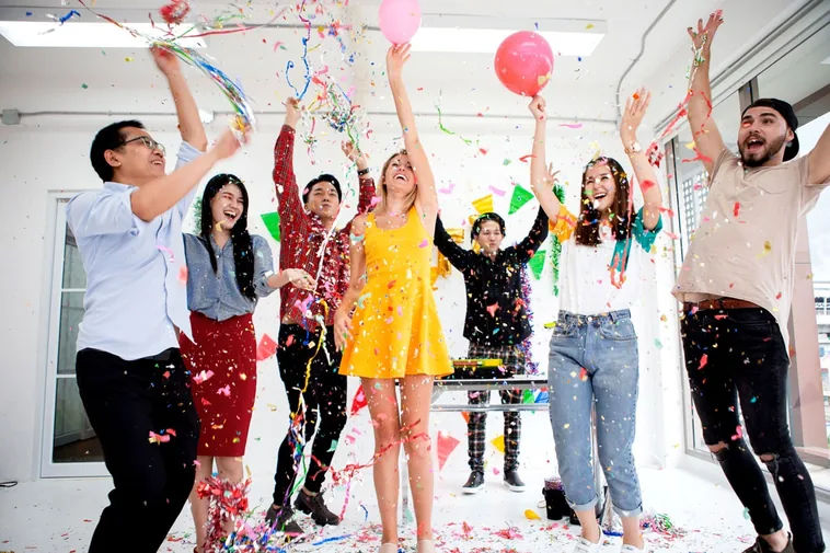 Collega's vieren met confetti en ballonnen